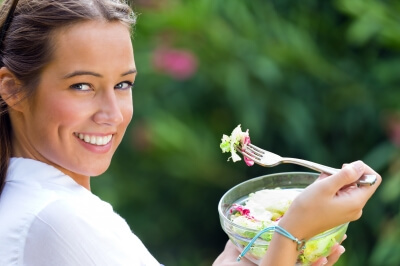 Woman holding green salad